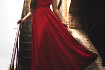 woman wearing red dress standing on staircase